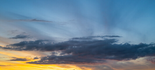 Sunset background. Dramatic sunset. Sky with clouds in sunset sky light background. Sunrise with clouds dawn sky. Calm sunset sky and sun through clouds over.