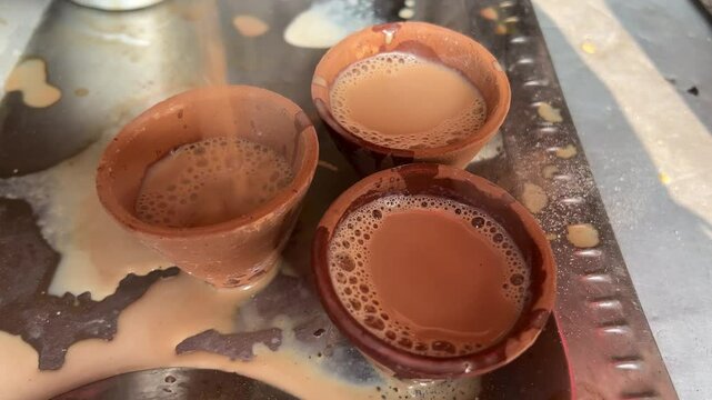 Filling of hot tea in clay pot. Kolkata morning scenes.