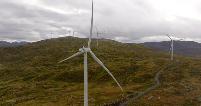 Drone view of spinning wind turbines atop Scandinavian mountain, energy crisis