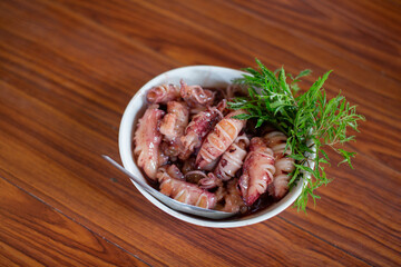 Sweet stir-fried squid eggs served on a white plate on a wooden table