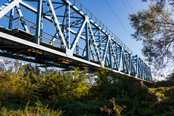 Fototapeta premium Construction of a railway bridge laid across a river, view from below