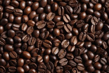 Fototapeta premium a close up of a pile of coffee beans with a few brown ones