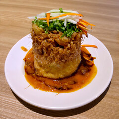 Fried egg tofu peanut sauce topped with sliced carrots, jicama and spring onions served on a white plate. Delicious unique cuisine in Indonesia