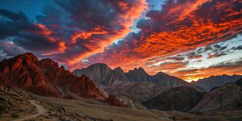 Fiery Sunset Hues Paint the Rugged Mountain Peaks and a Winding Trail Below