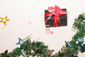 Season's greetings scene. Christmas decorations,gift boxes with red ribbons, сhristmas balls,  rustic star, holly berries, frosty spruce branches, confetti on white backdrop, selective focus with blur