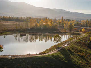 Drone view of landscape of a lake near the mountain at evening. A beautiful trees reflected in the...