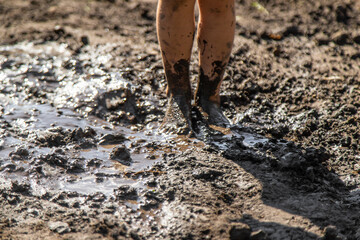 Child playing in mud. Selective focus.