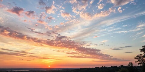 Fototapeta premium A breathtaking sunset vista showcasing a vibrant array of pastel hues painted across the evening sky, above a tranquil landscape
