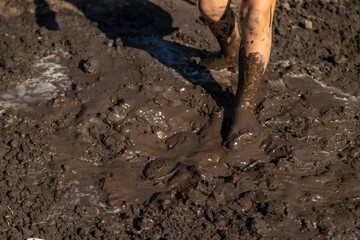 Child playing in mud. Selective focus.