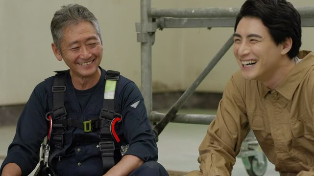 休み時間に休憩する工事現場で働く男性作業員