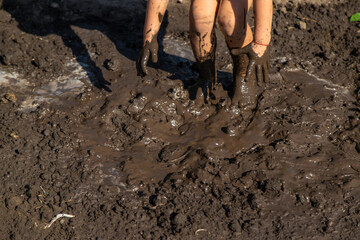 Child playing in mud. Selective focus.