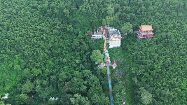 Aerial Fly above Wat Ban Tham Buddhist temple in Khao Noi, Thailand landscape of green lush jungle