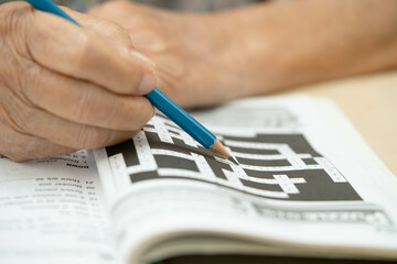 elderly woman playing sudoku puzzle game.