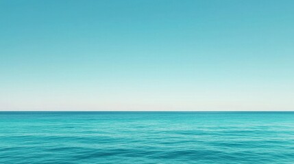 Obraz premium A serene seascape featuring calm, turquoise waters under a clear blue sky, evoking tranquility and the beauty of nature.