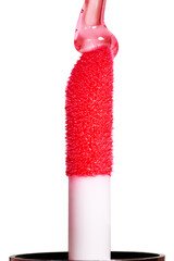 Drop of red liquid lip gloss falls on applicator. Closeup shot, isolated on white