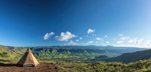 A lone tent pitched on a hilltop, with a panoramic view of a lush green valley and the rugged mountains beyond, under a bright blue sky with a few clouds drifting by.