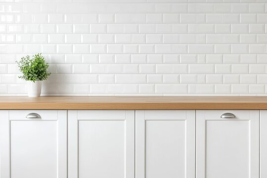 White kitchen cabinets with wood countertop and plant against white subway tile backsplash.