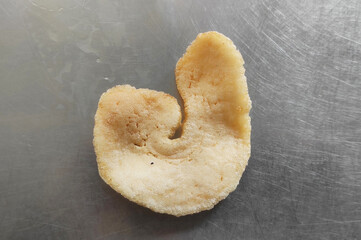 prawn crackers with a shape like the letter J, possibly a snack or chips, close-up food...