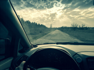 Naklejka premium inside the car. driver behind the wheel. drive a car. journey. bad roads. by car . steering wheel and dashboard. wheels and engine.