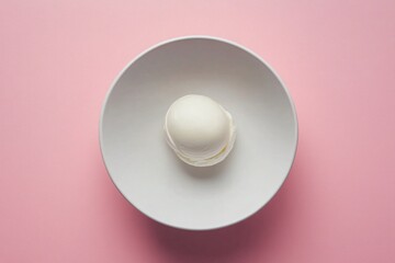 Single Scoop of Ice Cream on White Plate over Pink Background