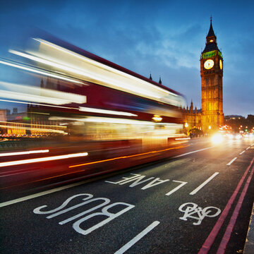Light trails from a London bus on Westminster Bridge with Big Ben in the background at night, London, England, UK