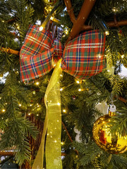 Christmas decoration parcel, ribbon and balls on the green Christmas tree