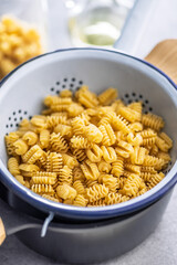 Uncooked italian pasta. Radiatori pasta in colander.