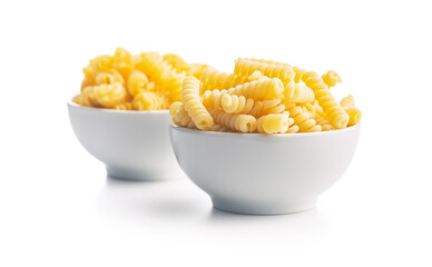 Uncooked italian pasta. Fusilli pasta in bowl isolated on white background.