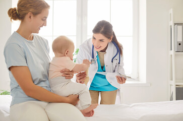 Mother brings baby for an appointment with a pediatrician doctor at a clinic, ensuring the child...
