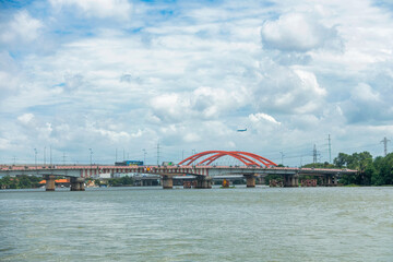 Fototapeta premium An airplane is flying over Binh Loi Bridge, Ho Chi Minh City, preparing to land at the airport.