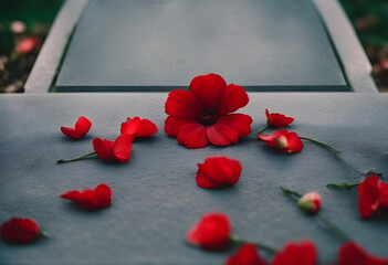 A red flower and petals on a concrete tombstone. RIP.