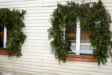 Christmas decoration of the facade and windows of the building with natural pine needles