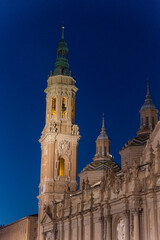 Obraz premium Detail shot of one of the towers of the Basilica del Pilar in Zaragoza at night illuminated by the lights.