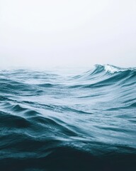 Fototapeta premium Serene ocean waves rolling under a misty sky.