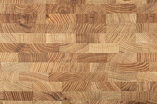 Oak wooden board as background, top view. Cross section of tree trunk. Natural durable end grain hard wood cutting board.