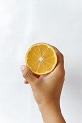 Hand Holding a Lemon with Studio Lighting on White Background