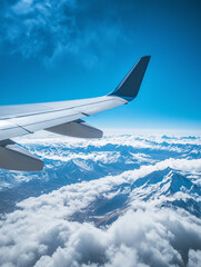 Fototapeta premium View from the window onto an airplane wing. Mountain peaks and clouds, view from an airplane. Traveling by airplane. 