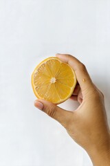 Hand Holding a Lemon with Studio Lighting on White Background