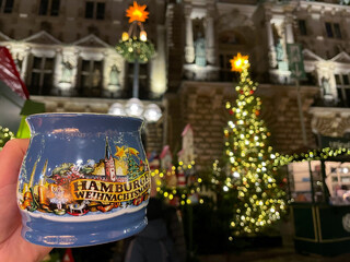 Traditional cup with painted of Hamburg sightseeings with hot mulled wine on the famous Christmas market on Rathausmarkt