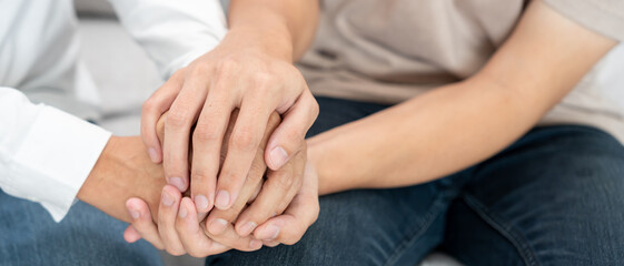 psychiatrist hold hand support each while discussing family issues. doctor encourages and empathy...