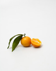 oranges and tangerines with leaves whole and in size lie on a white background