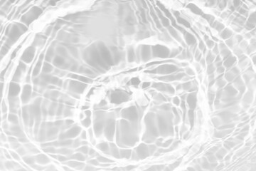 White water with ripples on the surface. Defocus blurred transparent white colored clear calm water surface texture with splashes and bubbles. Water waves with shining pattern texture background.