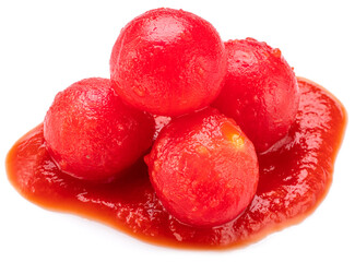Peeled cherry tomatoes in tomato sauce or ketchup puddle close-up on a white background.