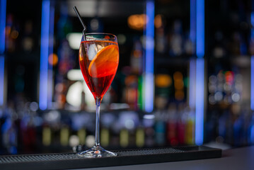 Close up of cold drink in a dark night bar, italian aperol spritz, wine-based cocktail, consists of Prosecco wine, digestive bitters, soda water and oranges.