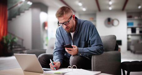 Man Calculating Finance Online On Couch
