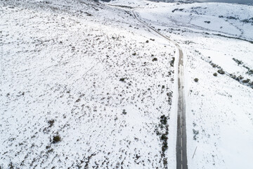 snow-covered mountain road from above, a winter wonderland. aerial perspective of a mountain road winding through snow