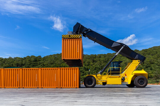 Reach stacker cargo forklift container box import export logistic transportation industrial, Reach stacker pick up container, Reach stacker container loader crane lifting maritime cargo container.