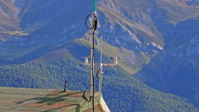 Weather station with anemometer on the roof of a mountain house