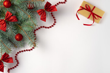 Christmas tree branch with decorations and gift box on white background. Flat lay, top view. Copy space