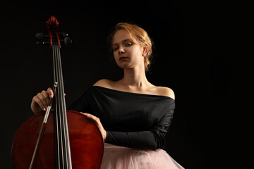 Beautiful young woman with cello on black background © New Africa